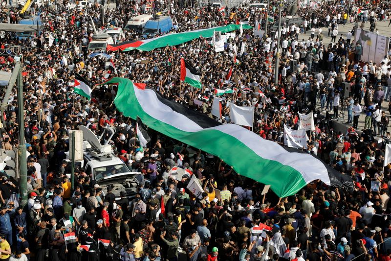 &copy; Reuters. متظاهرون عراقيون يلوحون بالأعلام الفلسطينية خلال احتجاج في بغداد يوم السبت. تصوير: خالد الموصلي - رويترز.