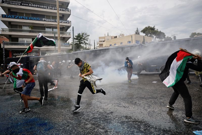 &copy; Reuters. أفراد من الشرطة اليونانية يطلقون مدافع المياه على متظاهرين مؤيدين للفلسطينيين في أثينا يوم السبت. تصوير: الكيس قنسطنطنيدس - رويترز.