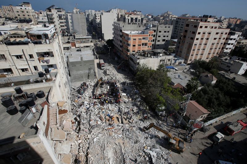 &copy; Reuters. عمال انقاذ يبحثون عن ناجين بين حطام مبنى انهار نتيجة غارات جوية إسرائيلية في مدينة غزة يوم الأحد. تصوير: محمد سالم - رويترز