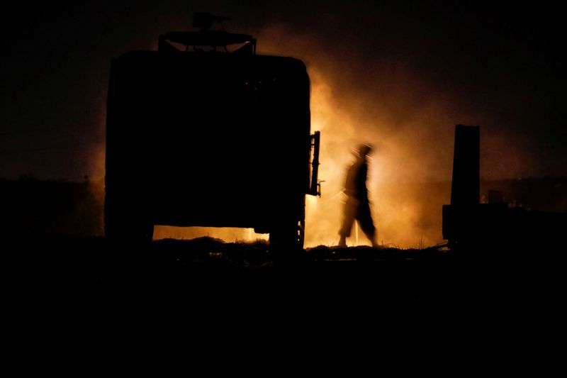 &copy; Reuters. An Israeli soldier walks next to a military vehicle at a mobile artillery unit location on the Israeli side by the Israel border with Gaza May 16, 2021. REUTERS/Baz Ratner