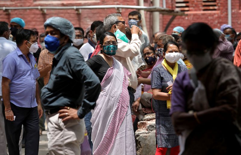 © Reuters. People wearing protective face masks wait to receive their second dose of COVISHIELD, a coronavirus disease (COVID-19) vaccine manufactured by Serum Institute of India, outside a vaccination centre in Kolkata, India, May 12, 2021. REUTERS/Rupak De Chowdhuri
