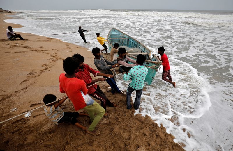 &copy; Reuters. People move a fishing boat to a safer place along the shore ahead of Cyclone Tauktae in Veraval in the western state of Gujarat, India, May 17, 2021. REUTERS/Amit Dave