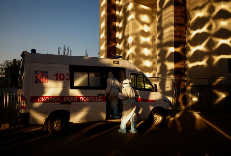 &copy; Reuters. Medical specialists get into an ambulance outside a pavilion of the Exhibition of Achievements of National Economy (VDNH), which was converted into a temporary hospital for people suffering from the coronavirus disease (COVID-19), in Moscow, Russia Novemb