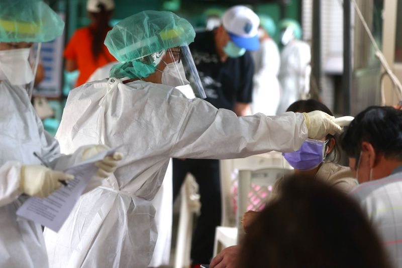 &copy; Reuters. 　５月１７日、台湾当局は、新型コロナウイルスの新規感染者が３３３人確認されたと明らかにした。市中感染が拡大している。写真は台北で検査を行う医療関係者（２０２１年　ロイター