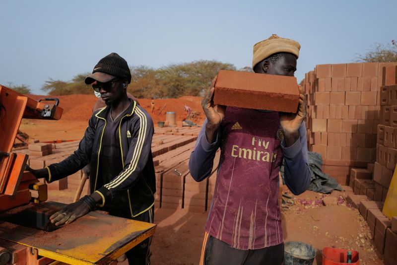&copy; Reuters. A worker carries a newly made brick at the Elementerre factory in Mbour, Senegal May 10, 2021.  REUTERS/Zohra Bensemra