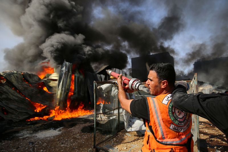 &copy; Reuters. Bombeiros palestinos combatem chamas em fábrica atingida por ataque de Israel em Gaza
17/05/2021
REUTERS/Ashraf Abu Amrah