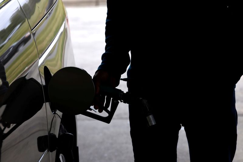 &copy; Reuters. FILE PHOTO: A motorist tops up the fuel in his car's gas tank after a lengthy wait to enter a gasoline station during a surge in the demand for fuel following the cyberattack that crippled the Colonial Pipeline, in Durham, North Carolina, U.S. May 12, 202