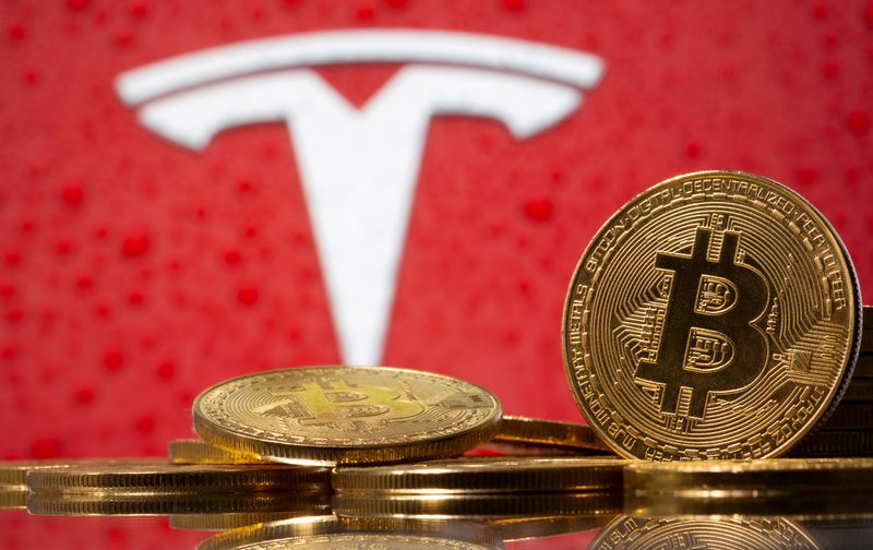 &copy; Reuters. Representação da moeda virtual bitcoin, com logotipo da Tesla ao fundo. 9/2/2021. REUTERS/Dado Ruvic
