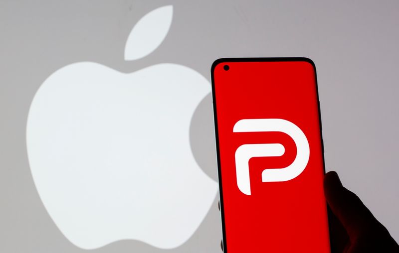 © Reuters. Woman holding smartphone with Parler logo in front of displayed Apple logo in this illustration taken May 17, 2021. REUTERS/Dado Ruvic