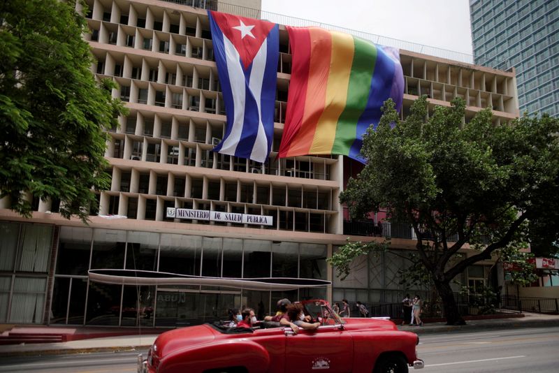 &copy; Reuters. People pass in a vintage car in front of a rainbow flag hanging beside a Cuban flag at the Health Ministry building in Havana, Cuba, May 17, 2021. REUTERS/Alexandre Meneghini     TPX IMAGES OF THE DAY