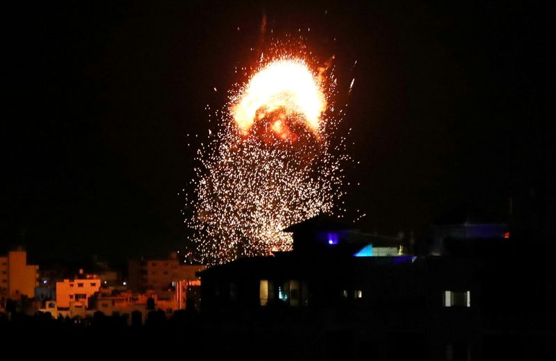 &copy; Reuters. دخان ونار تتصاعد فوق مبنى خلال غارة جوية إسرائيلية على غزة يوم الاثنين. تصوير: محمد سالم - رويترز