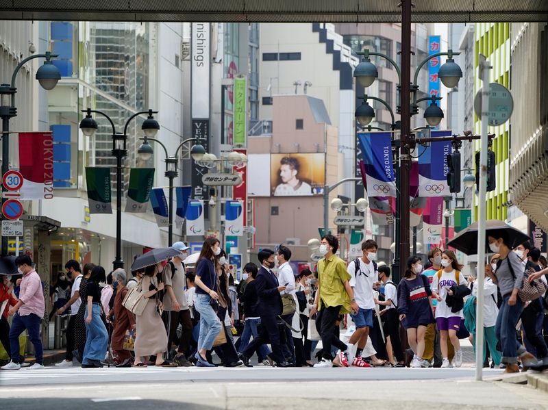 &copy; Reuters. 東京都は１８日、新たに７３２人の新型コロナウイルス感染が確認されたと発表した。写真は、ほぼ全員がマスクを着用している通行する人々。２０２１年５月１４日に都内で撮影。（２０
