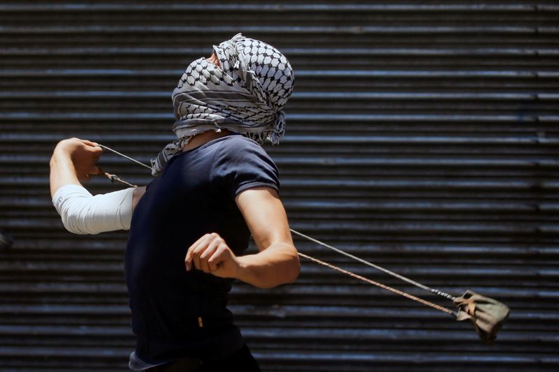 &copy; Reuters. Manifestante palestino atira pedra contra forças israelenses durante protesto em Gaza
18/05/2021
REUTERS/Mussa Qawasma