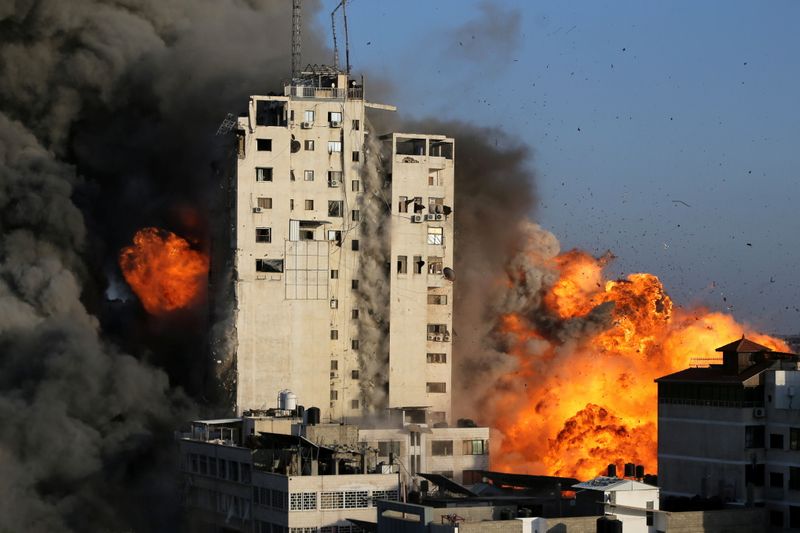 &copy; Reuters. Fumo e fiamme si alzano da un edificio colpito dagli attacchi aerei israeliani, a Gaza City il 12 maggio 2021. REUTERS / Ibraheem Abu Mustafa