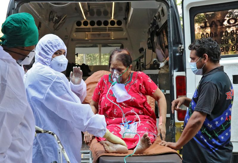 &copy; Reuters. Trabajadores sanitarios y familiares sacan a una mujer de una ambulancia para que reciba tratamiento en un centro de atención COVID-19, Mumbai, India, 4 mayo 2021.
REUTERS/Niharika Kulkarni