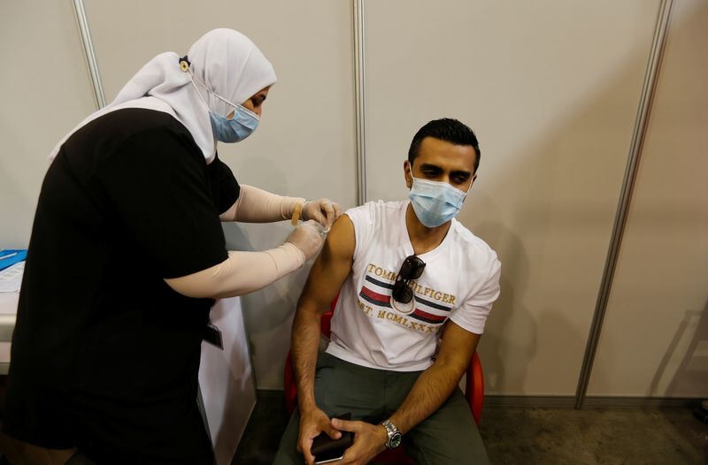 &copy; Reuters. رجل يحصل على تطعيم ضد كوفيد-19 في المنامة يوم 24 ديسمبر كانون الأول 2020. تصوير: حمد محمد  رويترز.