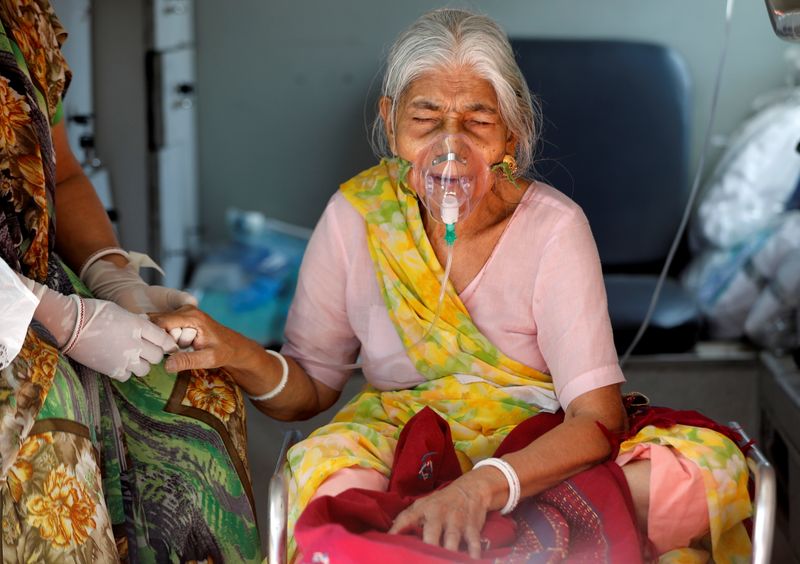 &copy; Reuters. FILE PHOTO: Lilaben Gautambhai Modi, 80, wearing an oxygen mask, sits inside an ambulance as she waits to enter a COVID-19 hospital for treatment, amidst the spread of the coronavirus disease (COVID-19), in Ahmedabad, India, May 5, 2021. REUTERS/Amit Dave