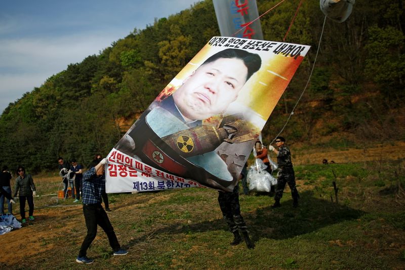 © Reuters. FILE PHOTO: Park Sang-hak (L), a North Korean defector and leader of an anti-North Korea civic group, holds a banner depicting North Korean leader Kim Jong Un with nuclear, tied on a balloon, near the demilitarized zone in Paju, South Korea, April 29, 2016.  REUTERS/Kim Hong-Ji/File Photo