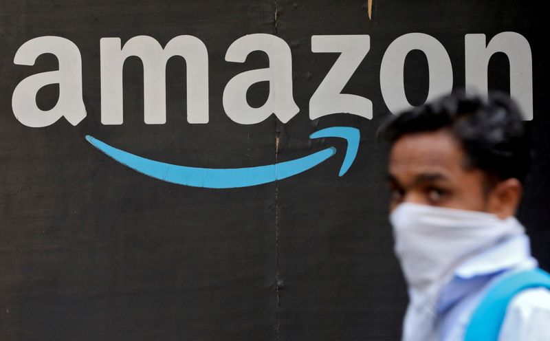 &copy; Reuters. FOTO DE ARCHIVO: Un hombre pasa junto a un logotipo de Amazon en Mumbai. 19 marzo 2021. REUTERS/Francis Mascarenhas/File Photo