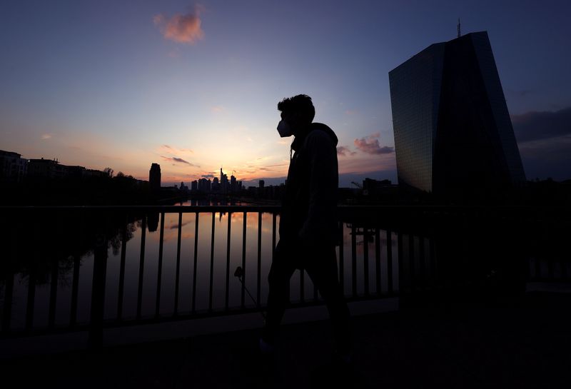 &copy; Reuters. FILE PHOTO: A man wearing a protective mask walks past the European Central Bank (ECB) during sunset as the spread of the coronavirus disease (COVID-19) continues in Frankfurt, Germany, April 18, 2021.  REUTERS/Kai Pfaffenbach