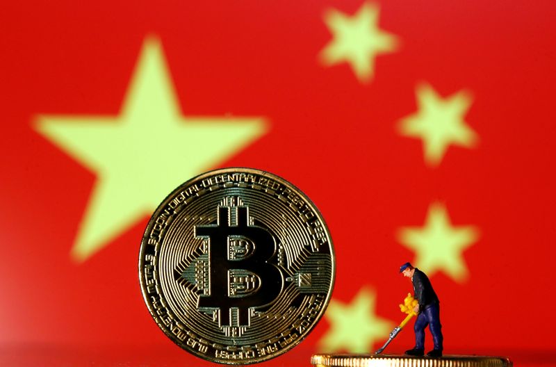 &copy; Reuters. Una piccola statuetta sulla rappresentazione della valuta virtuale Bitcoin di fronte a un'immagine della bandiera cinese, il 9 aprile 2019. REUTERS / Dado Ruvic  
