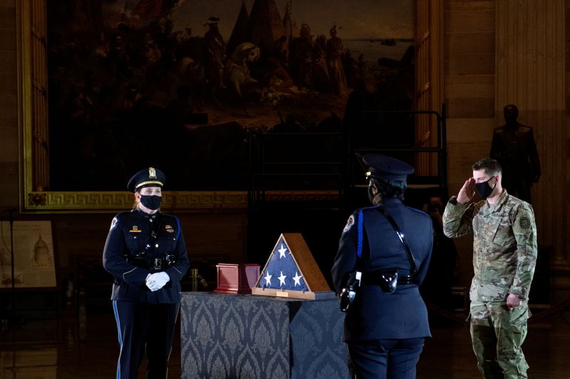 &copy; Reuters. FILE PHOTO: A member of the National Guard salutes while the remains of Capitol Police officer Brian Sicknick lay in honor in the Rotunda of the U.S. Capitol building in Washington, DC, U.S. February 2, 2021. Brendan Smialowski/Pool via REUTERS