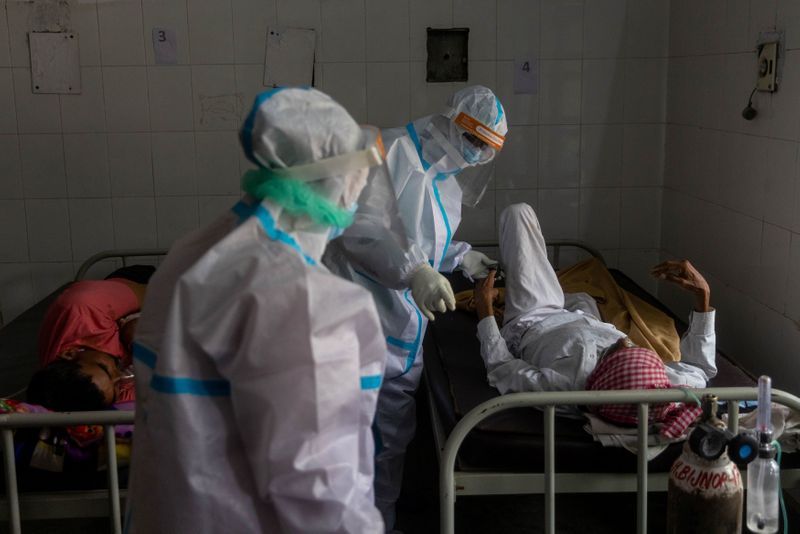 &copy; Reuters. FILE PHOTO: Medics tend to a man with breathing problems inside a COVID-19 ward of a government-run hospital, amidst the coronavirus disease (COVID-19) pandemic, in Bijnor district, Uttar Pradesh, India, May 11, 2021. REUTERS/Danish Siddiqui