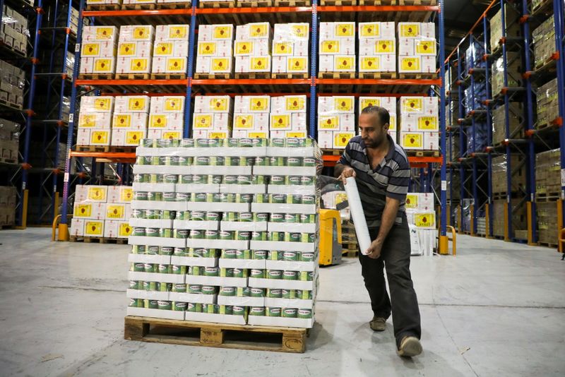 © Reuters. A worker wraps canned food with plastic at Bohsali food warehouse in Bchamoun, Lebanon, May 5, 2021. Picture taken May 5, 2021. REUTERS/Mohamed Azakir