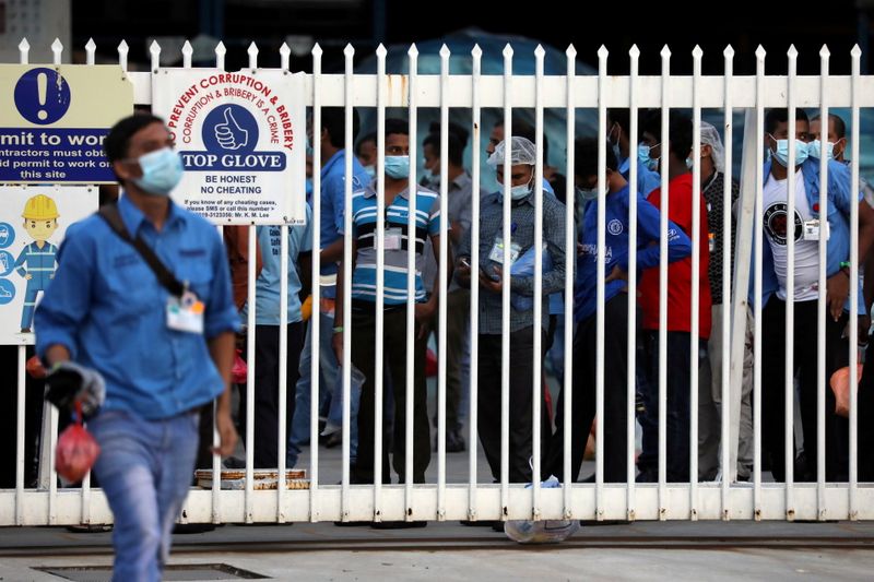 &copy; Reuters. FILE PHOTO: Workers wait in line to leave a Top Glove factory after their shifts in Klang, Malaysia December 7, 2020. Picture taken December 7, 2020. REUTERS/Lim Huey Teng - RC2ZLK9X2B1Q/File Photo