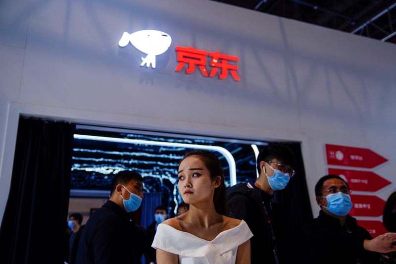 &copy; Reuters. FILE PHOTO: People stand under a JD.com company sign at the Appliance and Electronics World Expo (AWE) in Shanghai, China March 23, 2021.  REUTERS/Aly Song/File Photo 