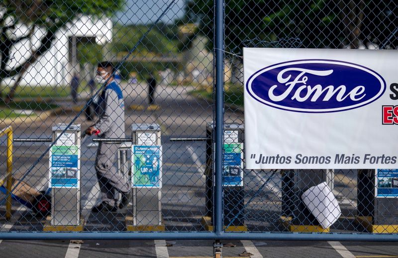 © Reuters. FILE PHOTO: Workers protest outside a Ford Motor Co plant, after the company announced it will close its three plants in the country, in Taubate, Brazil, January 18, 2021. The logo on the banner reads 'Hunger'. REUTERS/Roosevelt Cassio