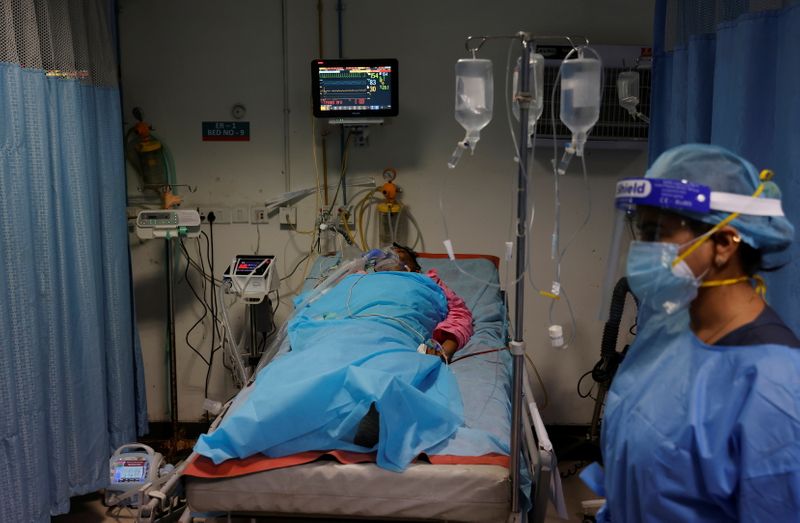 &copy; Reuters. FILE PHOTO: A man suffering from coronavirus disease (COVID-19) receives treatment as a Syringe Infusion Pump, donated by France is seen next to his bed, inside the emergency room of Safdarjung Hospital in New Delhi, India, May 7, 2021. REUTERS/Adnan Abid