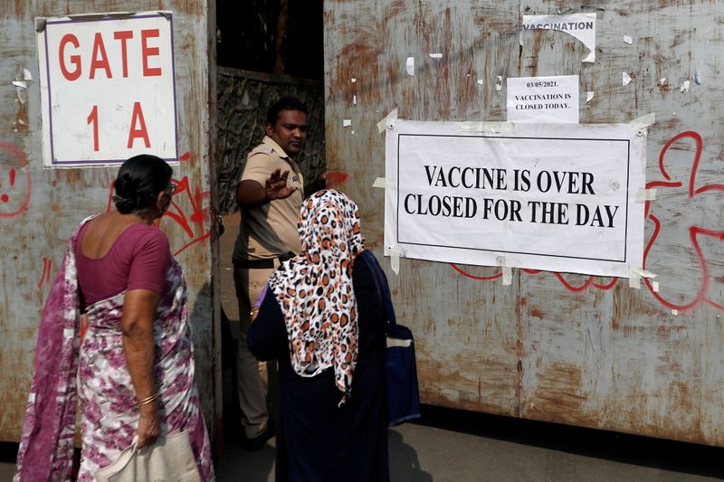 &copy; Reuters. FILE PHOTO: A policeman asks people who came to receive a dose of a coronavirus vaccine to leave as they stand outside the gate of a vaccination centre which was closed due to unavailability of the supply of COVID-19 vaccine, in Mumbai, India. REUTERS/Fra
