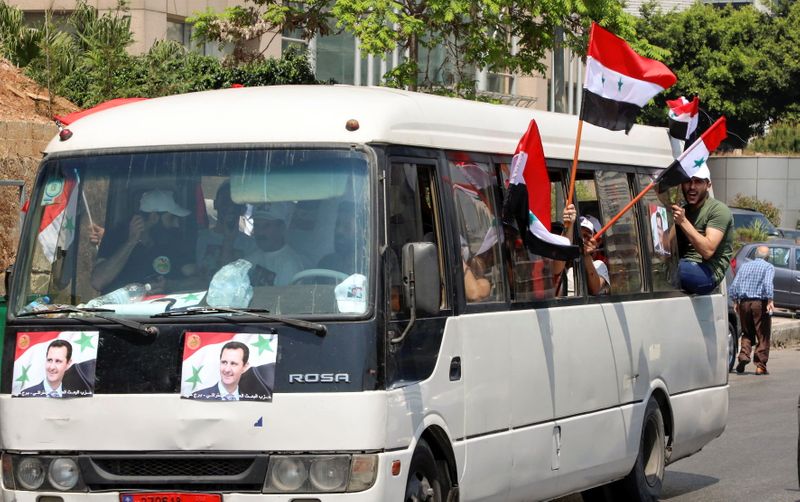 &copy; Reuters. صورتان للرئيس السوري بشار الأسد على حافلة في بيروت يوم الخميس. تصوير: محمد عزاقير - رويترز