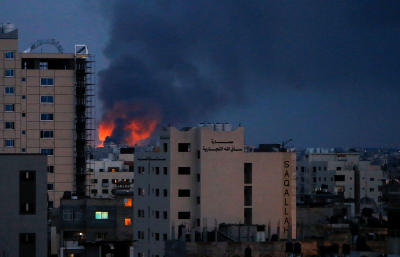 © Reuters. Smoke and flames are seen above buildings, amid a flare-up of Israeli-Palestinian fighting, in Gaza, May 20, 2021. REUTERS/Mohammed Salem