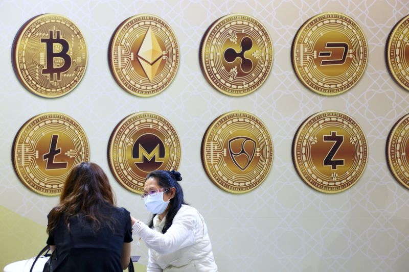 © Reuters. FILE PHOTO: Customers talk against a backboard with signs of cryptocurrency during 2020 Taipei International Finance Expo in Taipei, Taiwan, November 27, 2020. REUTERS/Ann Wang 