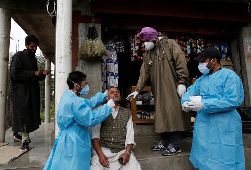 &copy; Reuters. A healthcare worker takes a nasal swab sample from a man for a coronavirus disease (COVID-19) test in front of a shop in Nawroz Baba village in central Kashmir's Budgam district May 20, 2021. REUTERS/Danish Ismail