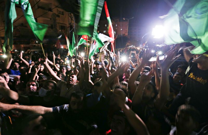 &copy; Reuters. فلسطينيون يحتفلون في الشوارع عقب وقف إطلاق النار بجنوب قطاع غزة يوم الجمعة. تصوير: إبراهيم أبو مصطفى - رويترز.