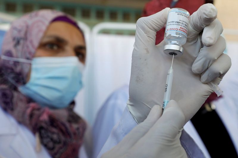 &copy; Reuters. FILE PHOTO: A Palestinian health worker prepares a vaccine against the coronavirus disease (COVID-19) after the delivery of doses from Israel, in Bethlehem in the Israeli-occupied West Bank, February 3, 2021. REUTERS/Mussa Qawasma/File Photo