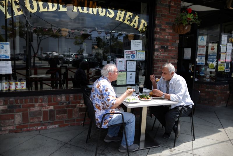 &copy; Reuters. FILE PHOTO: People eat at the King's Head pub as Los Angeles County moves into the least restrictive yellow coronavirus disease (COVID-19) disease reopening tier, in Santa Monica, California, U.S., May 6, 2021. REUTERS/Lucy Nicholson