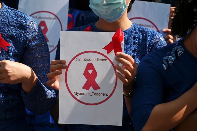 &copy; Reuters. FILE PHOTO: A teacher from Yangon University of Education holds a sign with a red ribbon while taking part in a demonstration against the military coup in Yangon, Myanmar, February 5, 2021. REUTERS/Stringer/File Photo