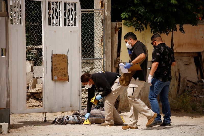 &copy; Reuters. Forensic investigators work at a scene where assailants left a package and a threat message taped to the gate of the house of Leticia Castillo, a candidate of the Social Encounter Party (PES) for the local congress, in Ciudad Juarez, Mexico May 21, 2021. 