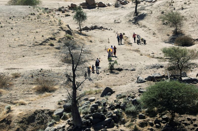 &copy; Reuters. FILE PHOTO: Ethiopians fleeing from the Tigray region walk towards a river to cross from Ethiopia to Sudan, near the Hamdeyat refugee transit camp, which houses refugees fleeing the fighting in the Tigray region, on the border in Sudan, December 1, 2020. 