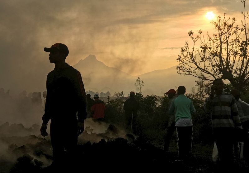 &copy; Reuters. Residents walk near destroyed homes with the smouldering lava deposited by the eruption of Mount Nyiragongo volcano near Goma, in the Democratic Republic of Congo May 23, 2021. REUTERS/Djaffar Al Katanty       