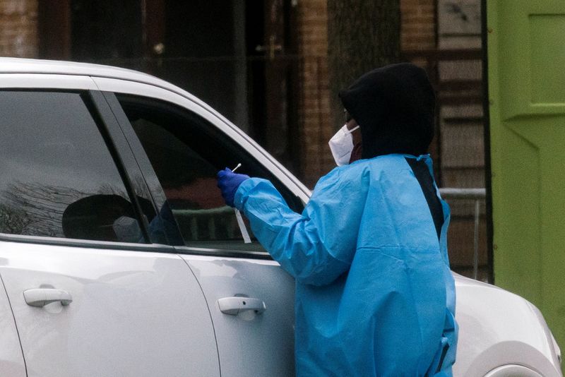 &copy; Reuters. FILE PHOTO: A health worker does a coronavirus disease (COVID-19) test as people wait at a drive-through COVID-19 testing center in a local street, in Newark, New Jersey, U.S., April 2, 2021. REUTERS/Eduardo Munoz