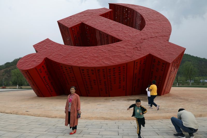 &copy; Reuters. Visitors are seen in front of a giant emblem of the Communist Party of China, ahead of the 100th founding anniversary of the party, during a government-organised tour at Nanniwan, a former revolutionary base of the party, in Yanan, Shaanxi province, China
