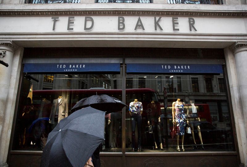 &copy; Reuters. FILE PHOTO: People shelter under umbrellas as they pass a Ted Baker a store in London, Britain October 06, 2015. REUTERS/Neil Hall/File Photo