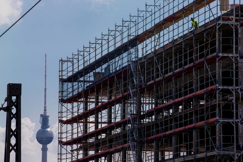 &copy; Reuters. FILE PHOTO: A worker is seen behind scaffoldings at a construction site near the Fernsehturm television tower in Berlin July 7, 2014. REUTERS/Thomas Peter