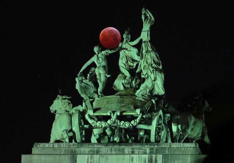 © Reuters. FILE PHOTO: The moon is seen beside a quadriga on the top of the Cinquantenaire arch during a total lunar eclipse, known as the 