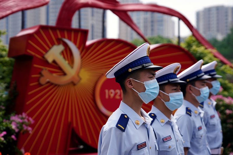© Reuters. Members of China Fire and Rescue Force pose for pictures near a sign marking the 100th founding anniversary of the Communist Party of China, outside the Memorial of the First National Congress of the Communist Party of China in Shanghai, China May 21, 2021. REUTERS/Aly Song